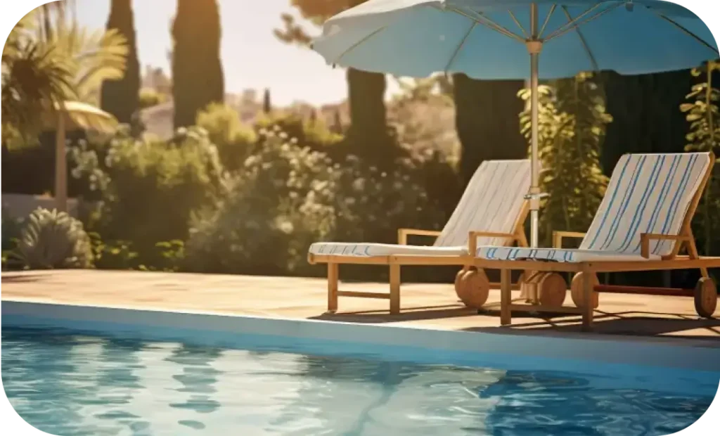 Wooden pool side loungers with striped cushions and umbrella by Urban Land Products – top manufacturer in India